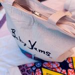 canvas bag with 'Baby Yams' branding on a colorful background with zipper